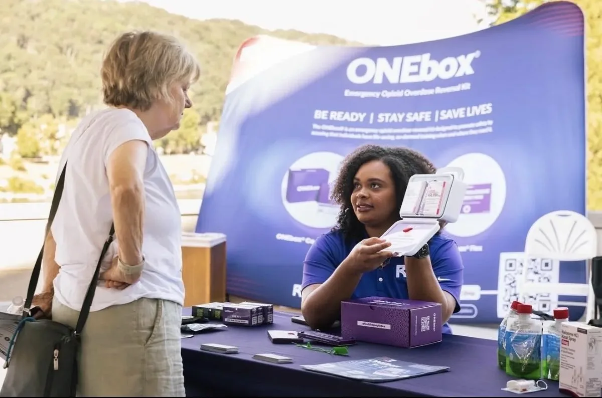 An R3 team member demonstrating the ONEbox at a community outreach event