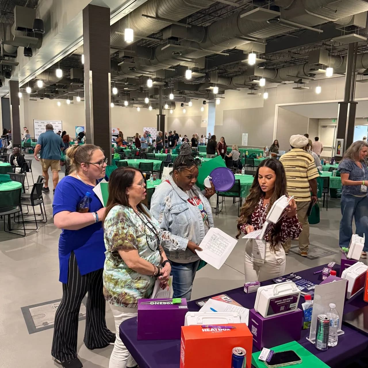 Attendees exploring ONEbox and HEATbox at a community expo
